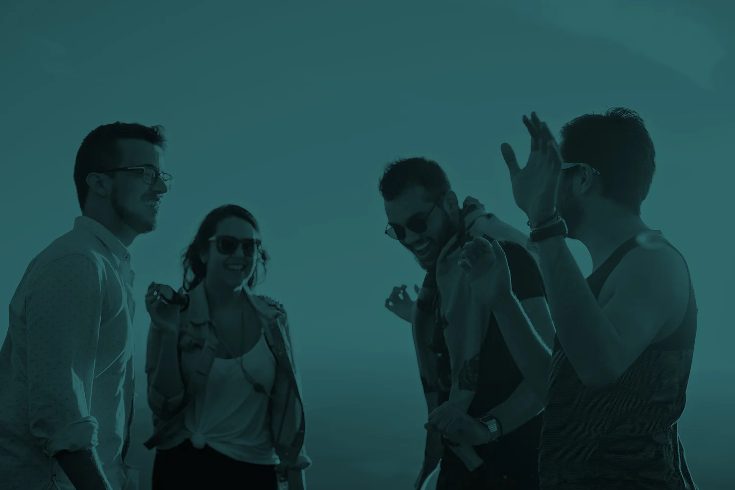 An executive team laughing together at sunset — Pangea leadership retreat